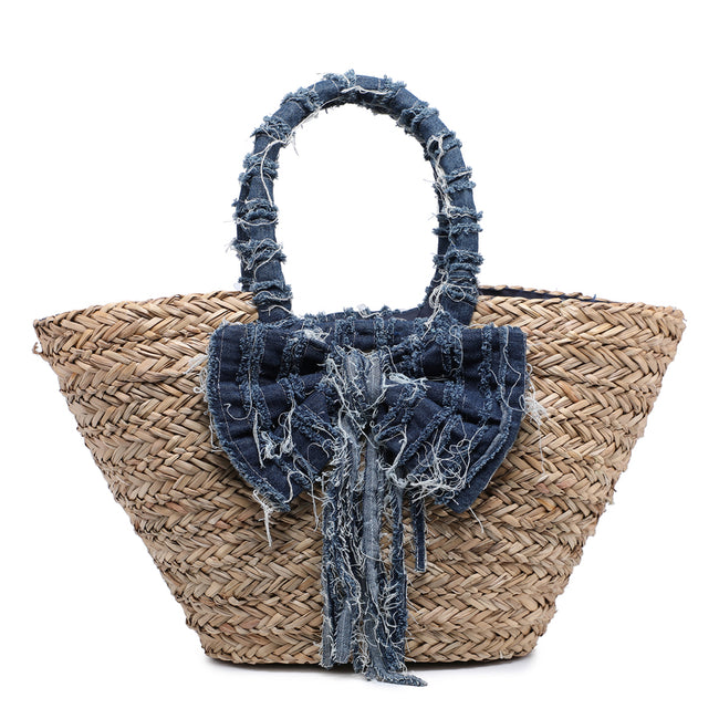 Natural woven tote bag with a large distressed blue bow and matching wrapped handles, front view.