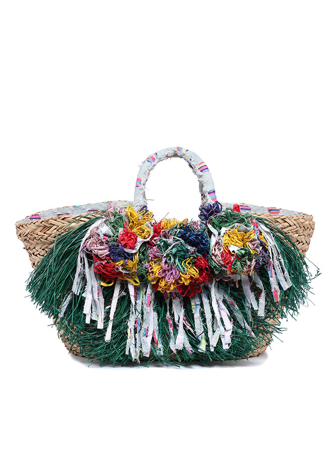 Natural woven tote bag with green fringe, multicolored floral decorations and pale patterned handles.