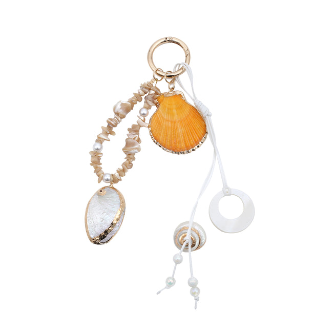 Keyring with a yellow scallop-shell charm, irregular pale beads, an oval shell pendant and white dangling cords.