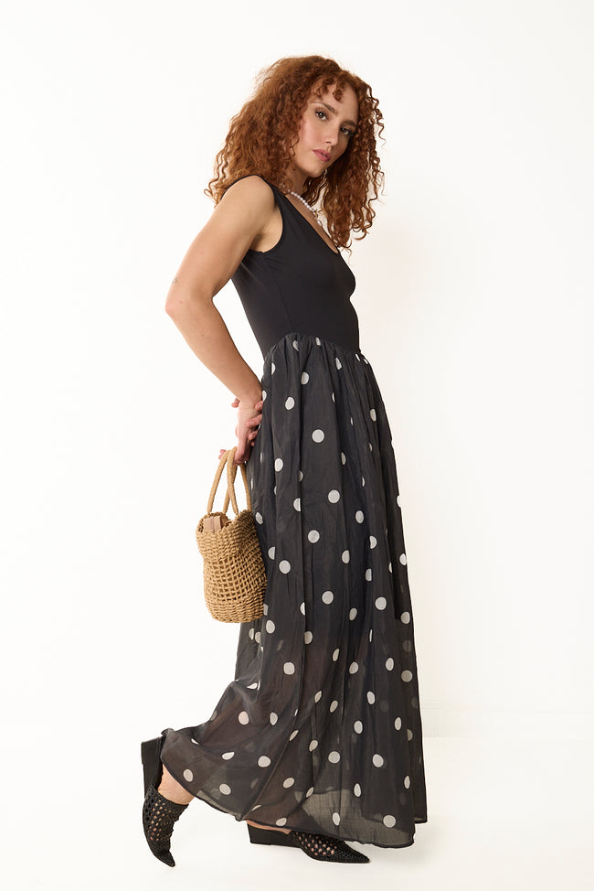Black sleeveless Tencel-polyester maxi dress with plain bodice, scoop neckline and gathered sheer polka dot skirt, side view