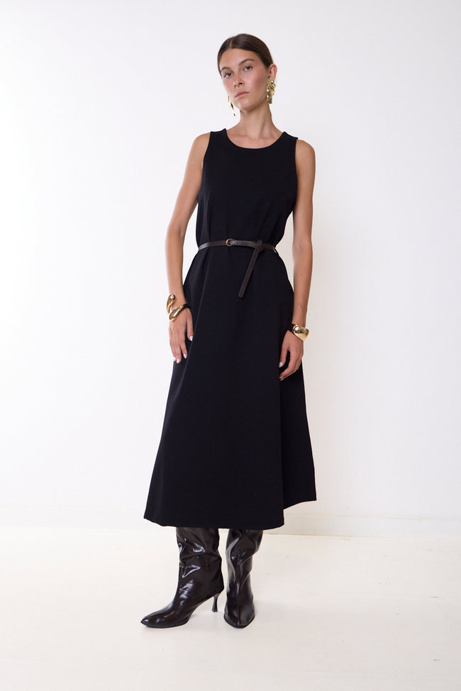 Black round-neck sleeveless midi dress with flared skirt, pictured with narrow waist belt; boots and jewellery styled separately