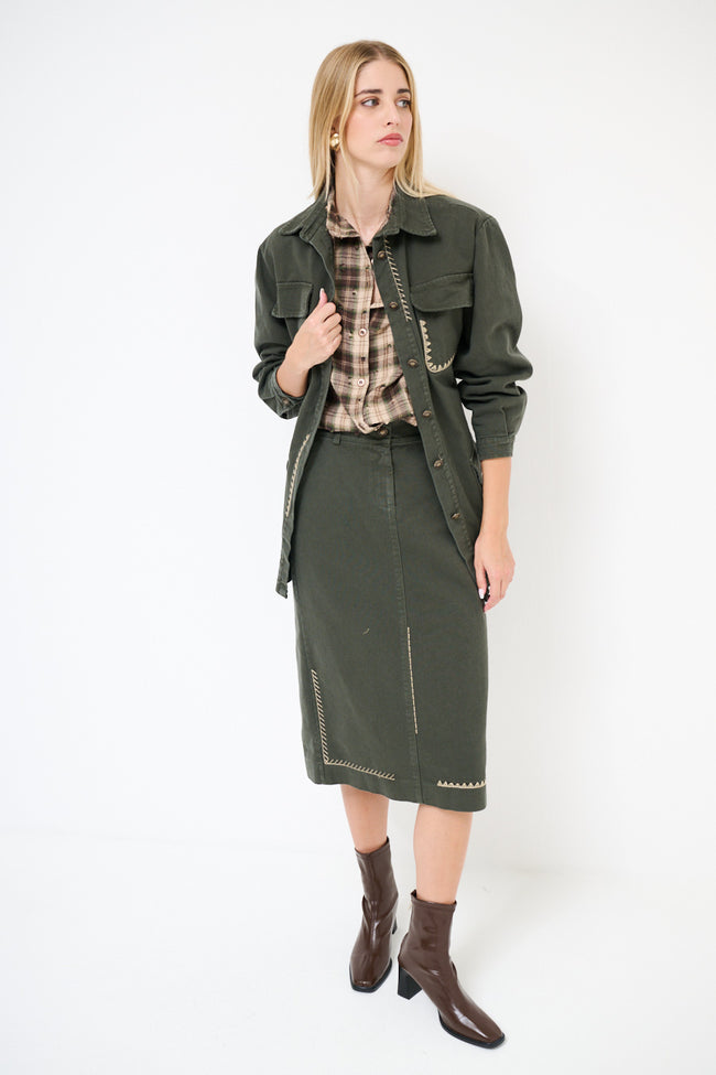Dark green belted utility shirt jacket with chest flap pockets, hip patch pockets and contrast embroidery