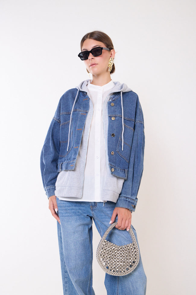Blue layered-look denim jacket pictured with grey drawstring hood and zip-front inner layer, front buttons, long sleeves, front pocket details and hem tabs; white shirt, jeans, bag and sunglasses styled separately