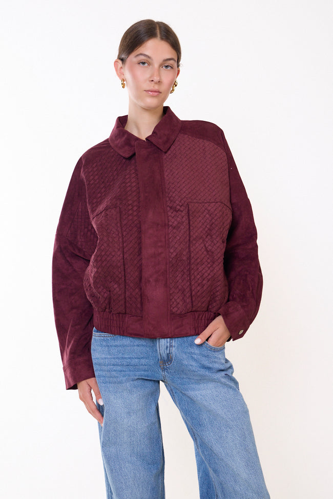 Bordeaux wine collared zip-front jacket with snap placket, textured front panels, front patch pockets, long sleeves with snap cuffs and gathered hem; jeans and black top styled separately