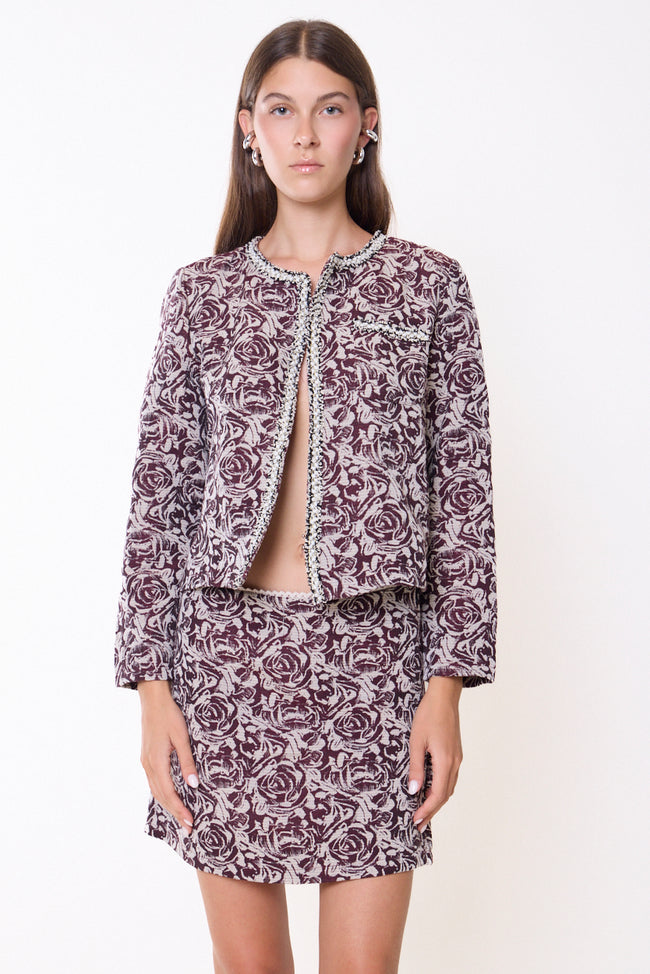 Bordeaux and cream floral pattern cropped collarless floral blazer with round neckline, long sleeves and embellished neckline, front-edge and chest trim; coordinating skirt or lace top, hat and jewellery styled separately