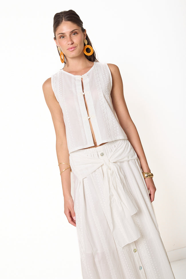 White textured cotton sleeveless cropped top with round neckline and front frog closures; matching midi skirt styled separately