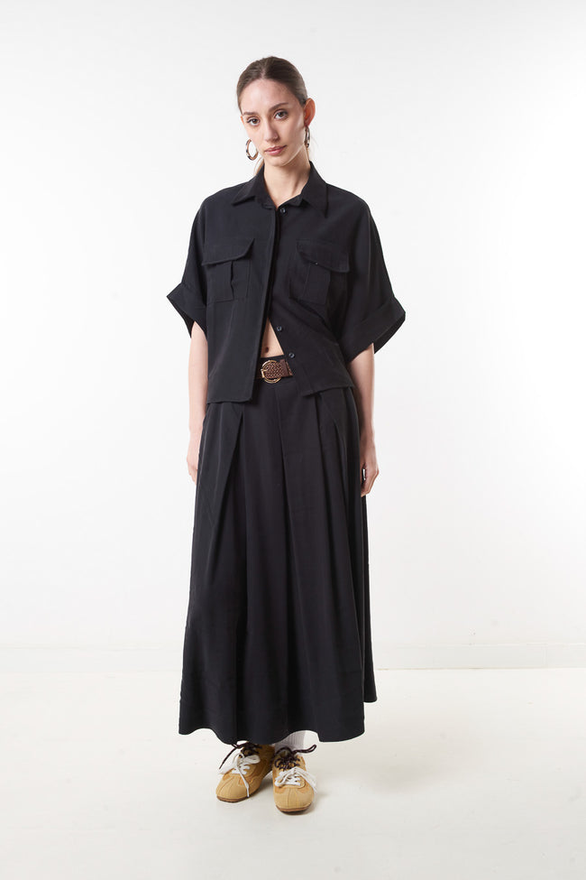 Black high-waist flowing midi skirt with front pleats, buckle belt and side pockets