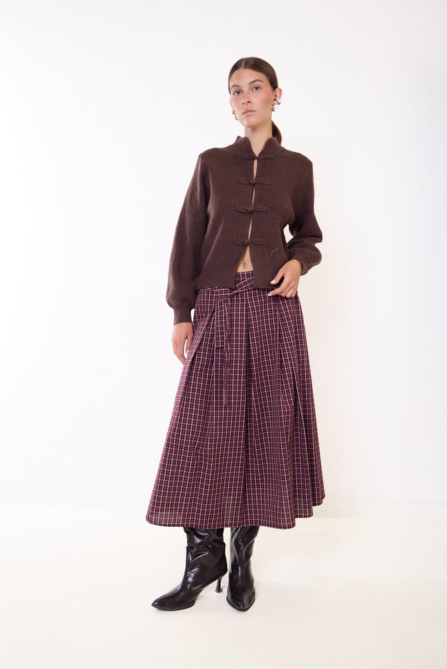 Bordeaux plaid plaid midi skirt with front tie detail, front pleats and flared silhouette; knit cardigan, hat and boots styled separately