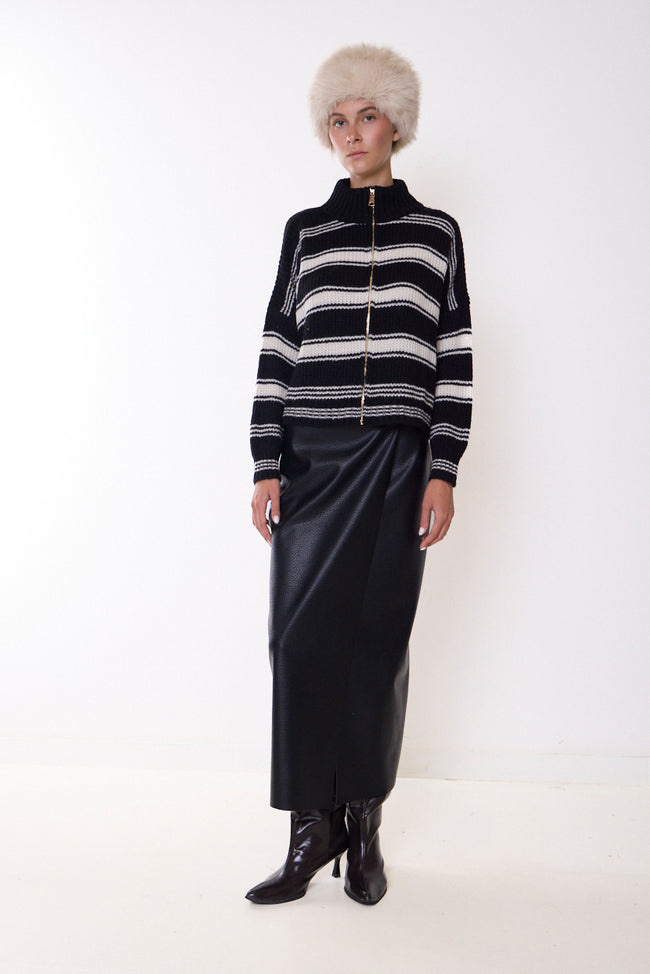 Black faux-leather midi skirt with straight silhouette, front view; striped zip-front cardigan, hat and boots styled separately