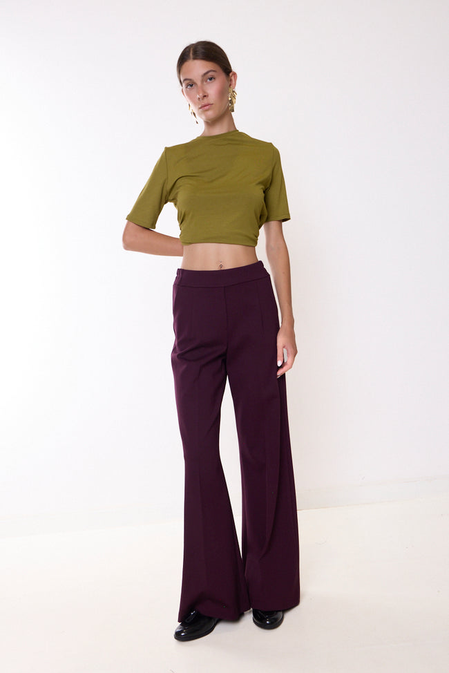 Bordeaux wide-leg full-length trousers with broad waistband and side pocket openings; short-sleeve top or blazer styled separately