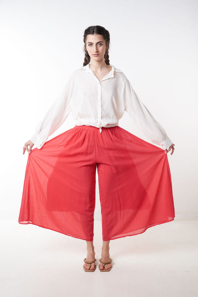 Red cropped wide-leg trousers with elastic waist and sheer outer layer