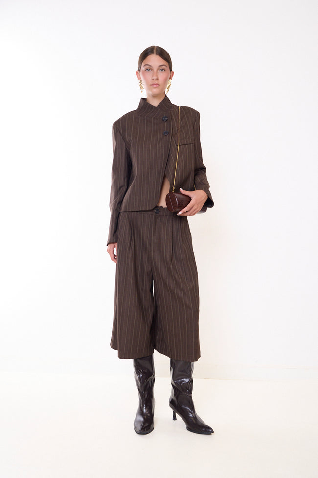 Coffee brown pinstripe fine-pinstripe wide-leg Bermuda shorts with front button, front pleats and side pocket openings; coordinating cropped jacket, bag, necklace and boots styled separately