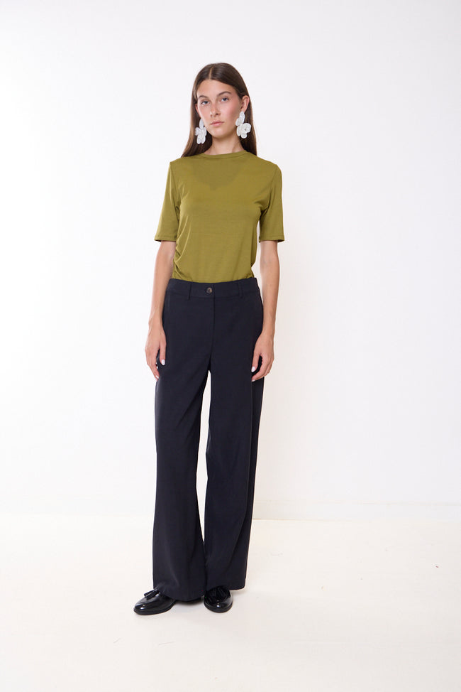 Black dark-navy-toned wide-leg full-length trousers with front button, belt loops and side pocket openings; short-sleeve top and shoes styled separately