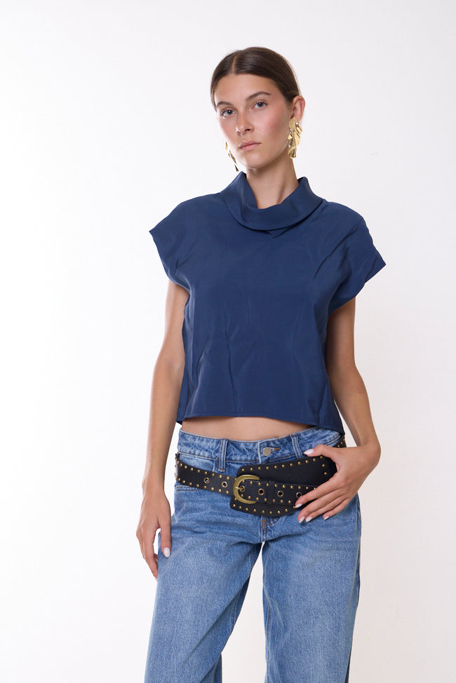 Blue cropped cowl-neck top with short cap sleeves; jeans and studded belt styled separately