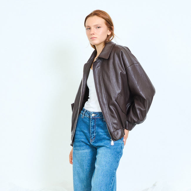 Coffee brown roomy faux-leather jacket with shirt collar, front zip, long voluminous sleeves, angled side pocket details and gathered back hem; plain top, jeans and shoes styled separately