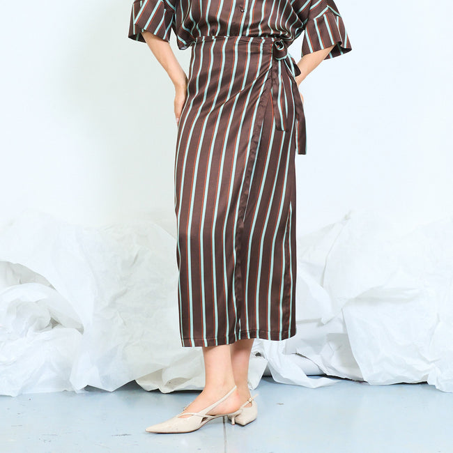 Coffee brown with teal stripes striped wrap midi skirt with overlapping front panel and side tie detail; coordinating striped blouse and shoes styled separately