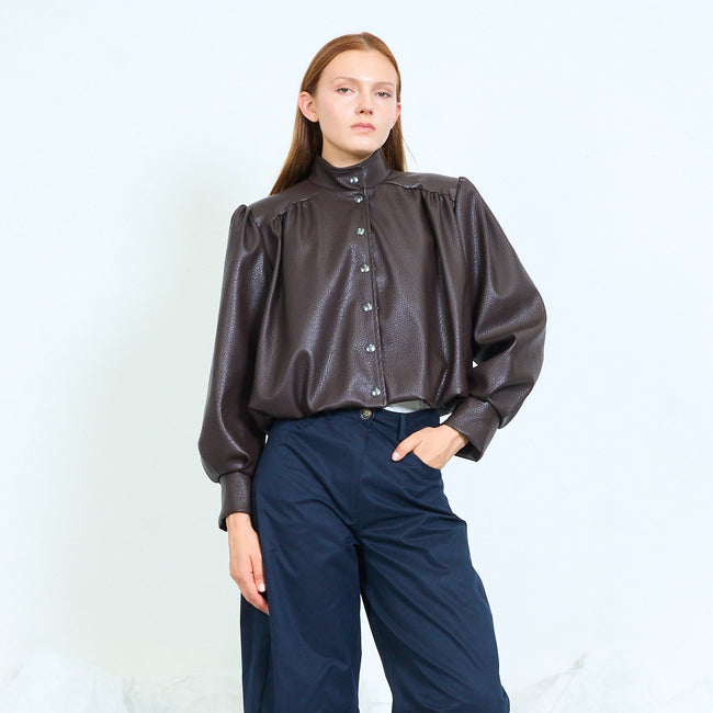 Coffee brown cropped faux-leather stand-collar button-front jacket with gathered shoulder seams, long voluminous sleeves, wide cuffs and gathered hem; jeans or trousers and shoes styled separately