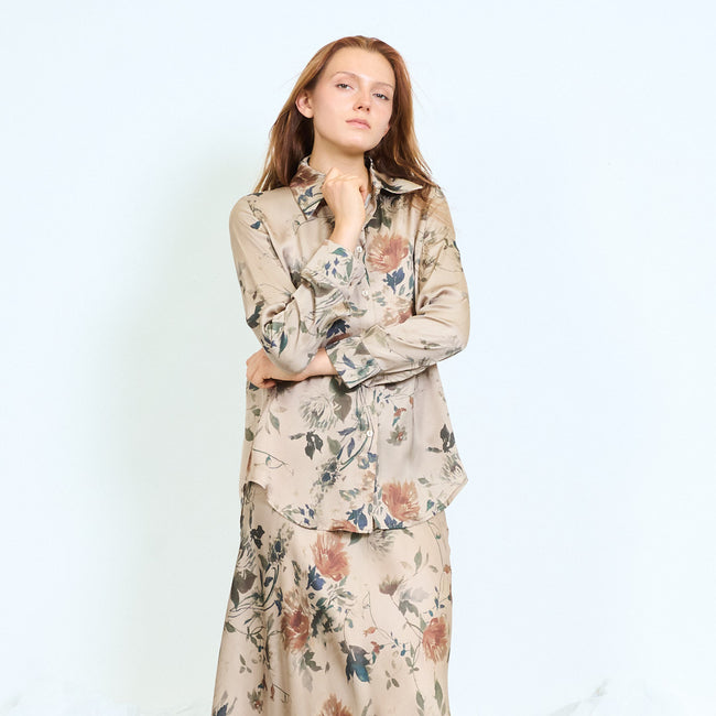 Beige taupe-ground floral-print button-front shirt with pointed collar, long sleeves, plain cuffs and curved hem; coordinating floral skirt and shoes styled separately
