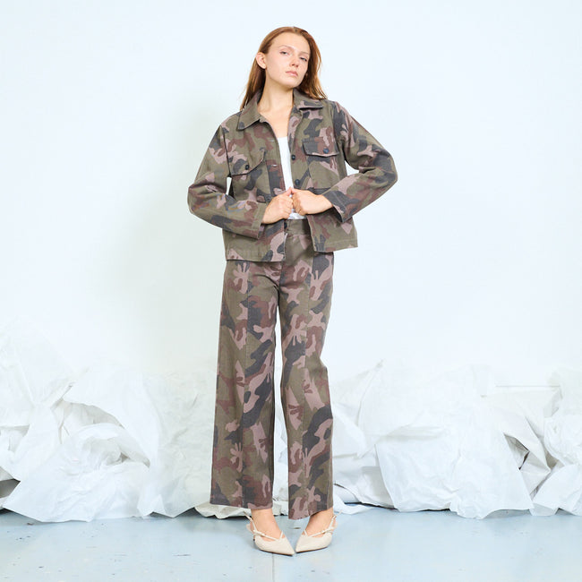 Olive green and brown camouflage wide-leg trousers with belt loops, front button and zip, angled side pocket openings and straight hems; plain top, coordinating jacket and shoes styled separately