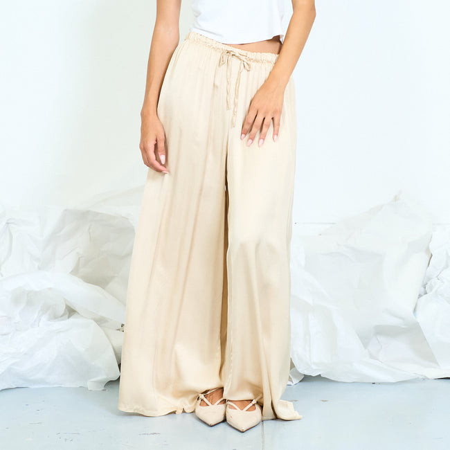 Cream glossy palazzo trousers with a drawstring waist.