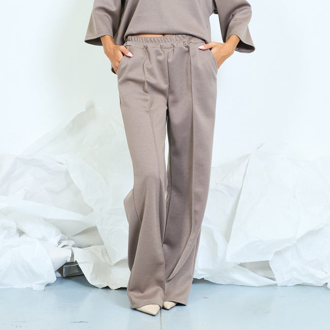 Taupe wide-leg trousers with front seams and gathered waistband.