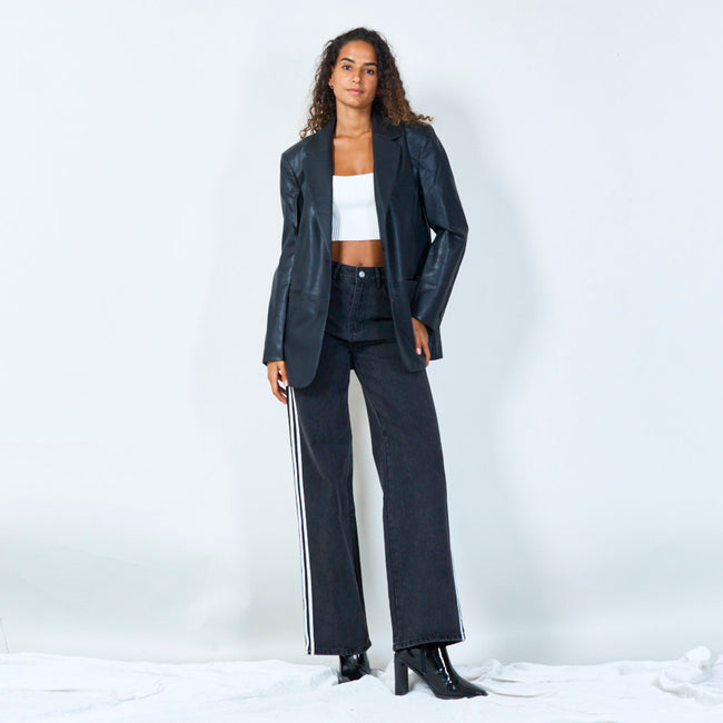Full-length view of a black blazer worn open with a white cropped top and wide-leg jeans.