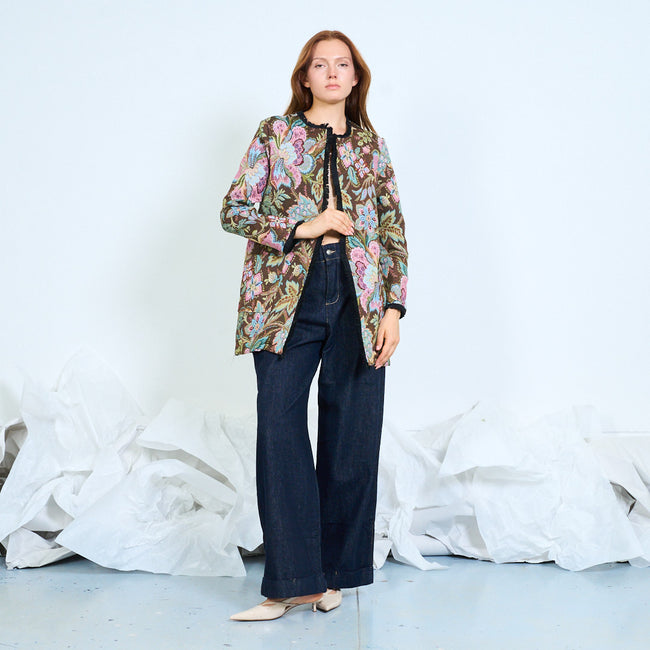 Coffee brown ground with multicoloured flowers floral jacquard open-front jacket with round neckline, front patch pockets, long sleeves and contrast fringe edging; top, trousers or dress and cap styled separately
