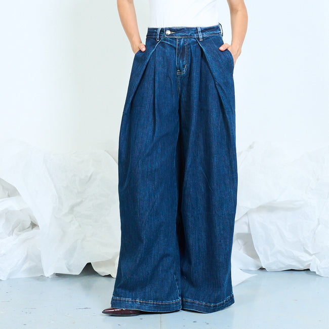 Front view of dark blue extra-wide-leg jeans with deep front pleats.