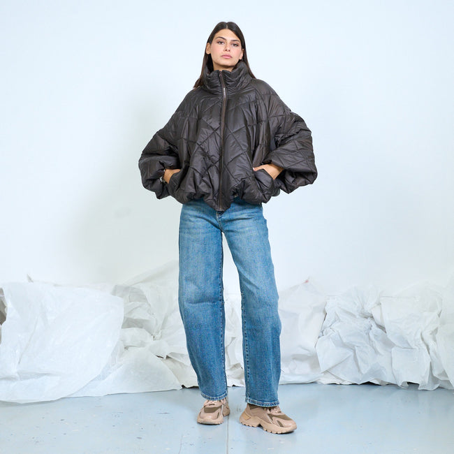 Model wearing a charcoal diamond-quilted jacket with voluminous sleeves