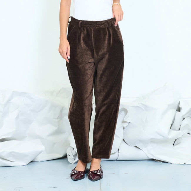 Front view of dark brown textured trousers with a tapered leg.