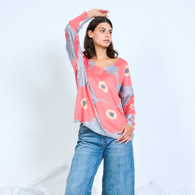 Grey V-neck top with oversized coral flowers, shown with one arm raised