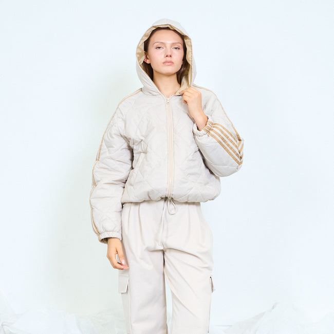 Light beige hooded quilted jacket with tan stripes along the sleeves.