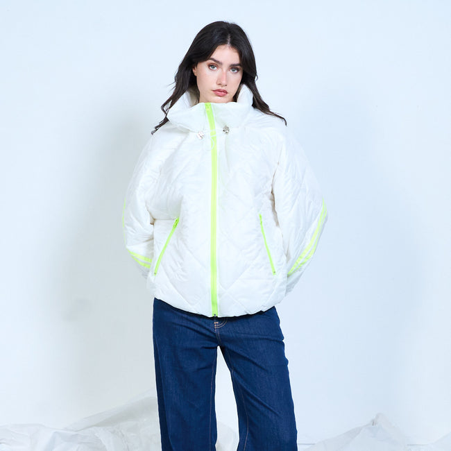 Model wearing a white quilted jacket with a high collar and neon yellow zip trim.